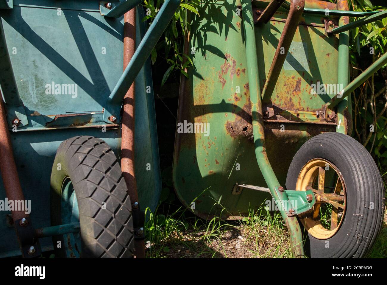 Two old wheelbarrows in a garden Stock Photo