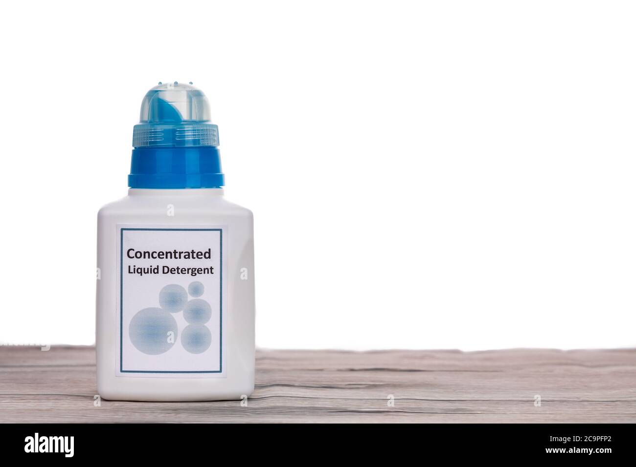 Tecnologically advanced compact concentrated laundry liquid detergent on wooden surface against white background Stock Photo