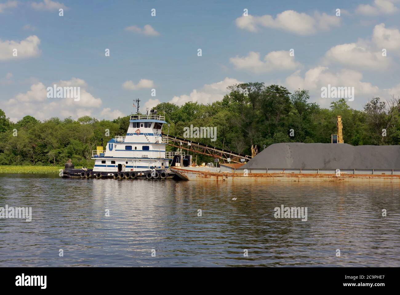 A tugboat is attached to a gravel barge awaiting shipment along the Nanticoke River in Seaford