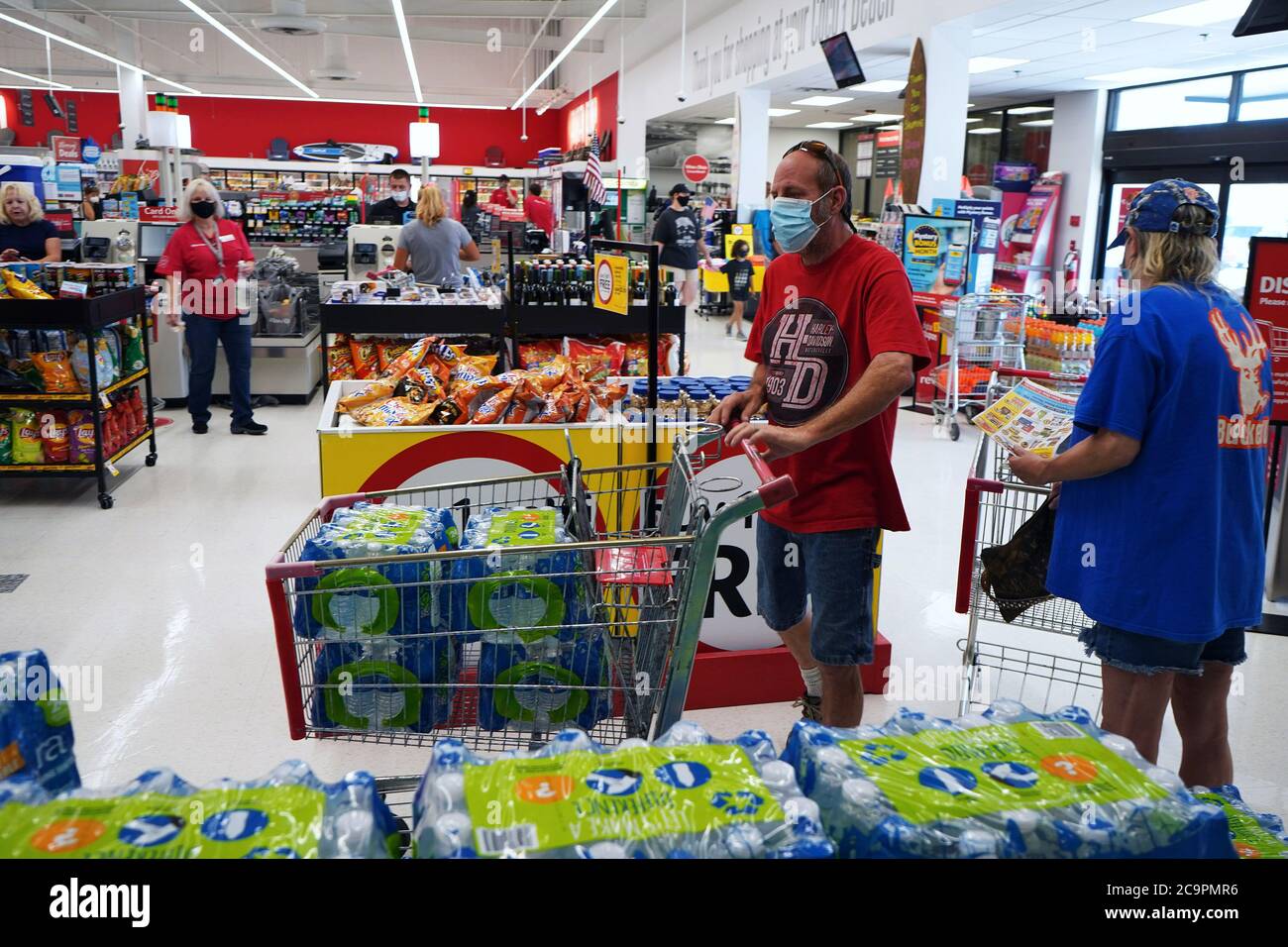Florida, United States. 01st Aug, 2020. A shopper wearing a protective face mask fills a grocery cart with bottled water at a Winn-Dixie supermarket in preparation for the arrival of Hurricane Isaias.The storm is forecast to approach the coast of Florida as a Category 1 storm and then parallel the Atlantic coast as it moves north. Credit: SOPA Images Limited/Alamy Live News Stock Photo