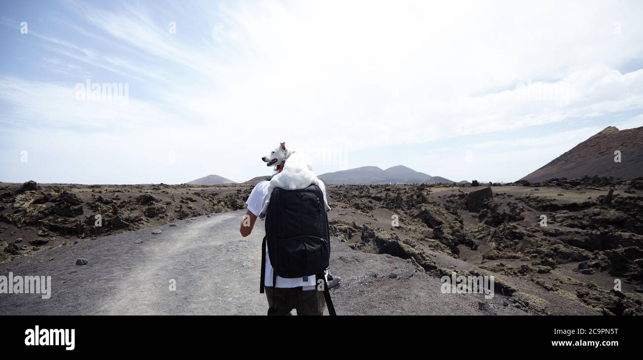 Frindship. Man and dog walking on a path in Lanzarote Stock Photo