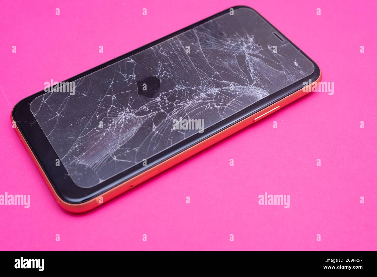 Broken glass mobile phone screen on a pink background Stock Photo - Alamy