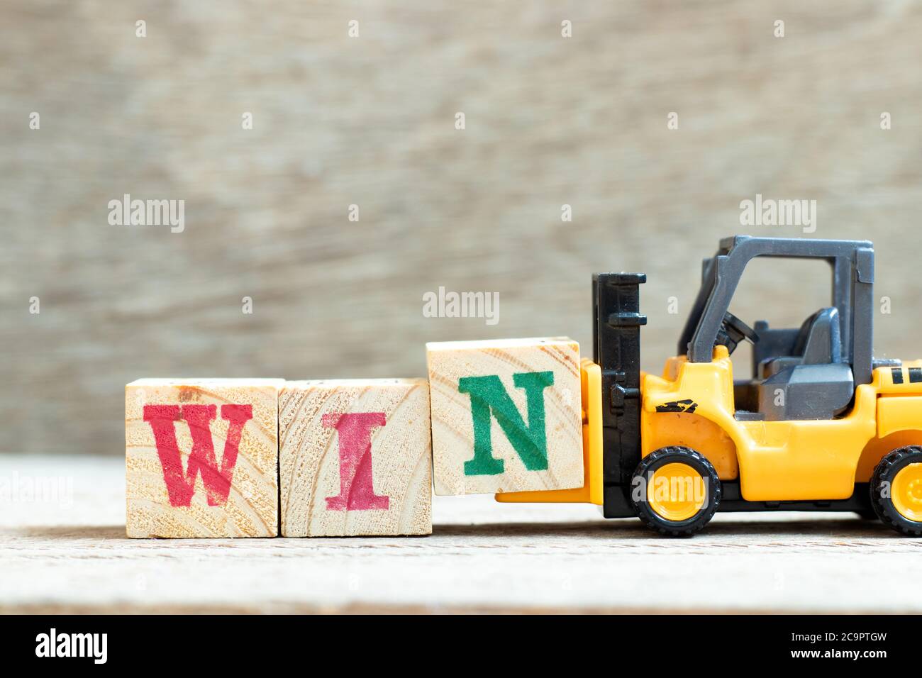 Toy forklift hold letter block n to complete word win on wood