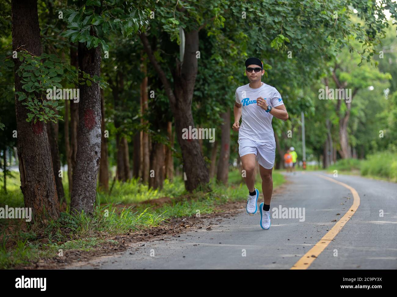 Asian men jogging and running in the park Stock Photo