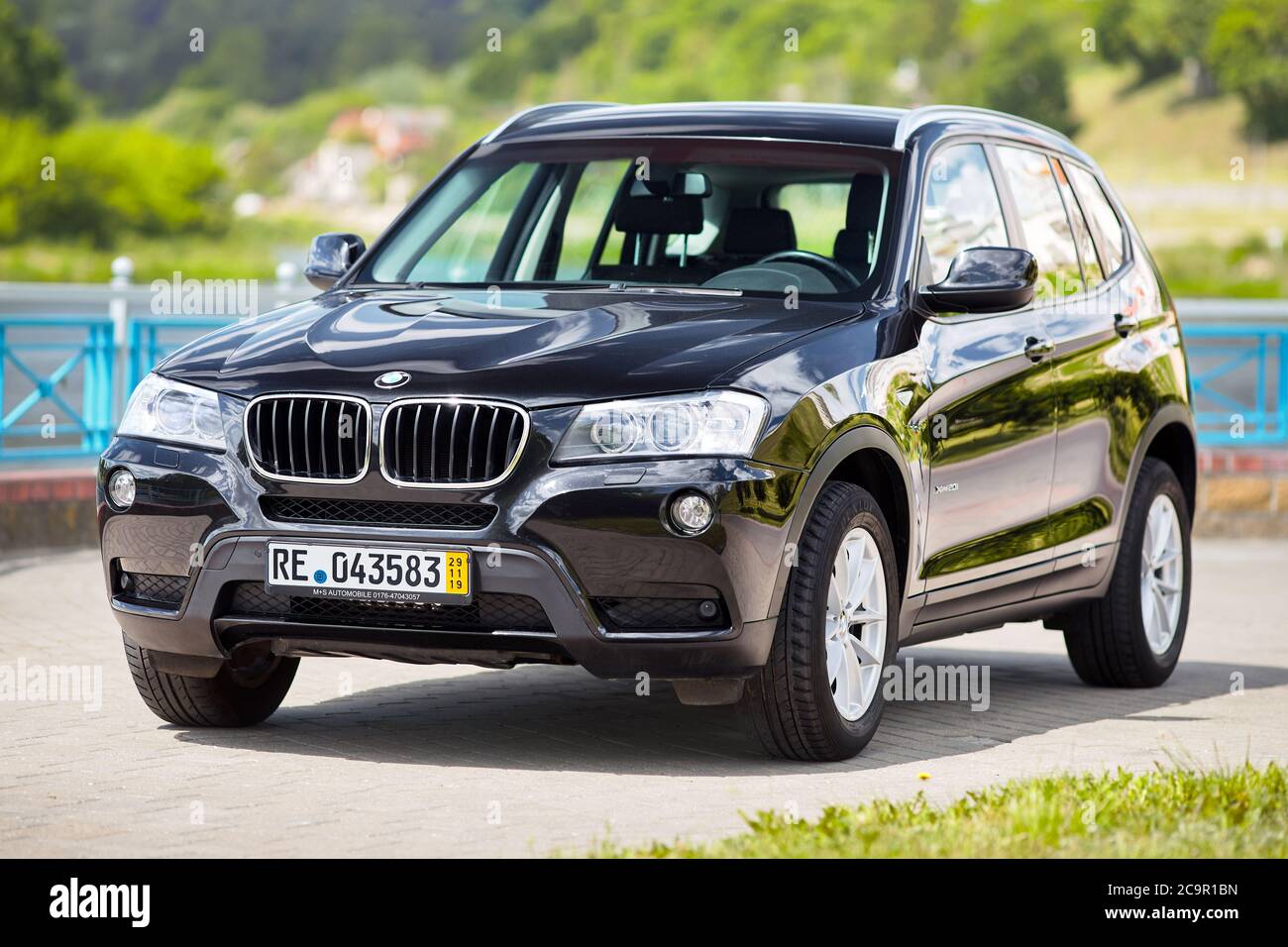 GRODNO, BELARUS - JUNE 2020: BMW X3 II F25 2.0i xDrive front three fourth view outdoors on sunny road background of summer city promenade foliage land Stock Photo