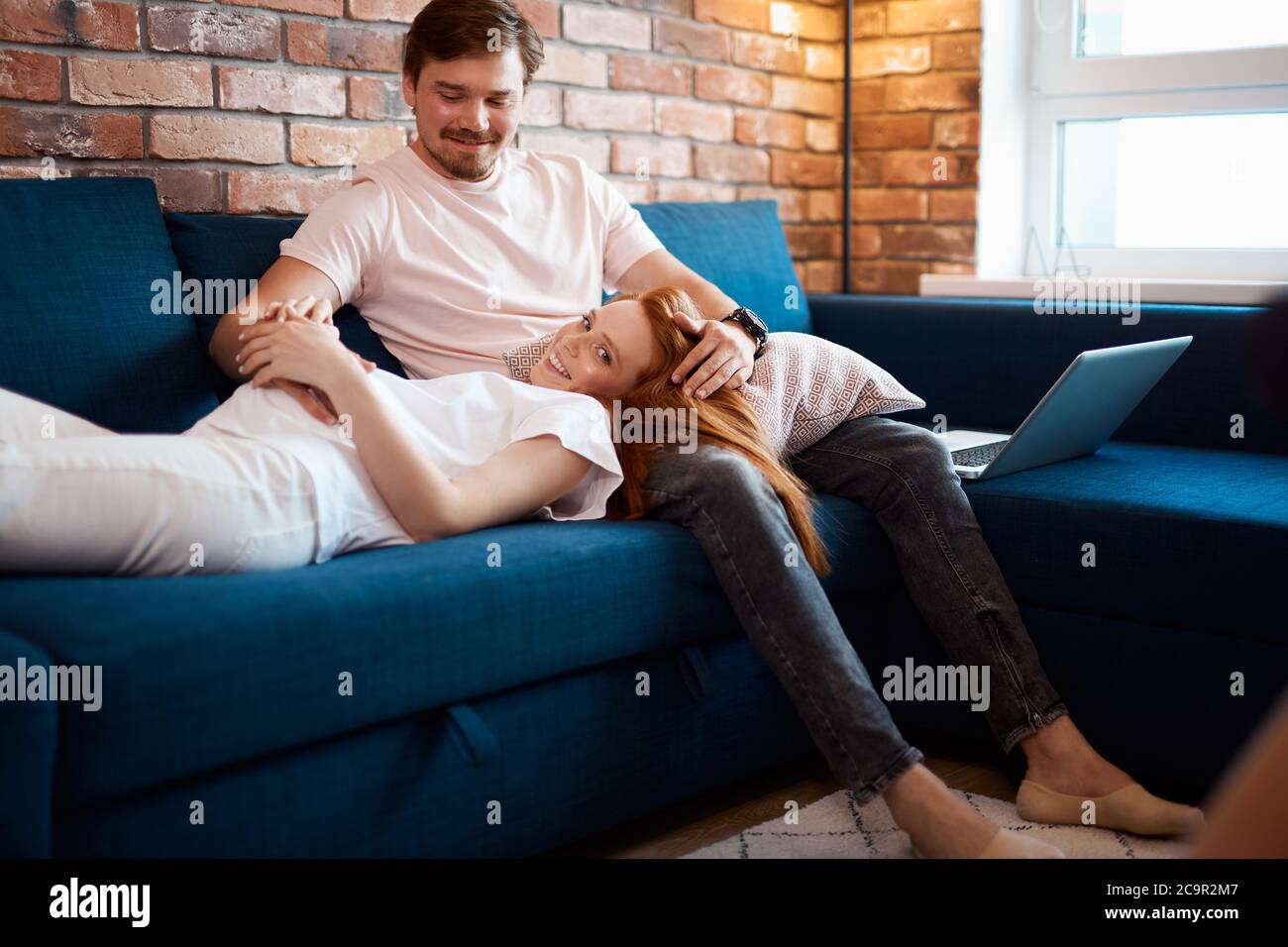 adorable pregnant woman lie on man's knees, redhead woman in love with