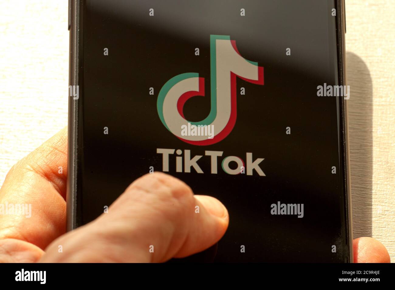 TikTok application icon on Apple iPhone 11 screen closeup. Hand