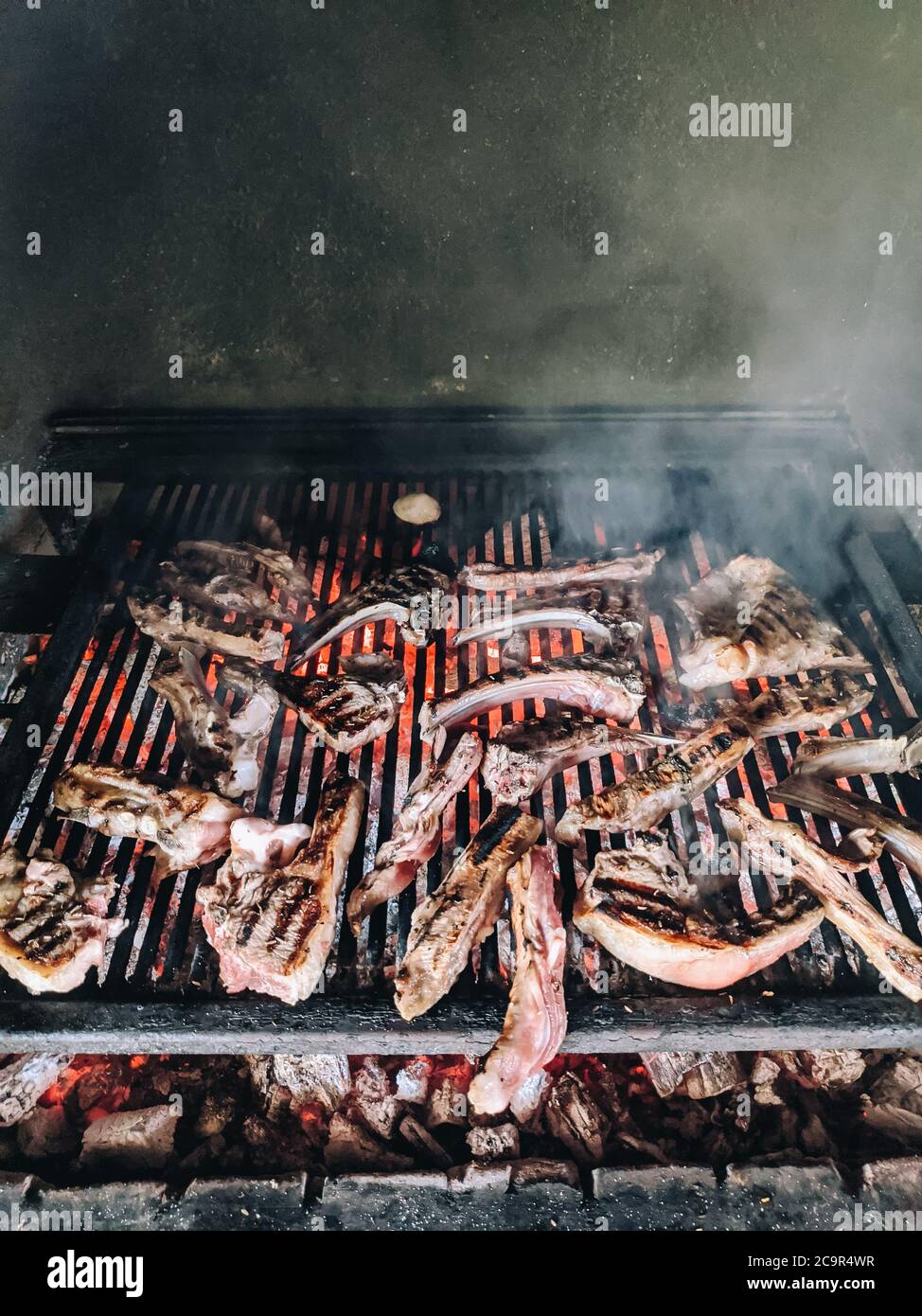 Grilled lamb ribs. Large metal grate with hot coals Stock Photo - Alamy