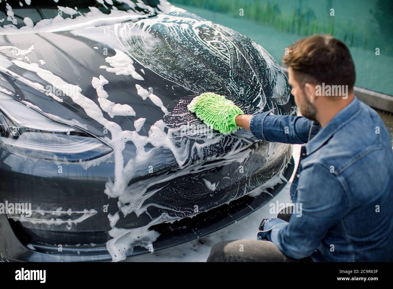 Premium Photo  A man washes his car at a selfservice car wash using a hose  with pressurized water