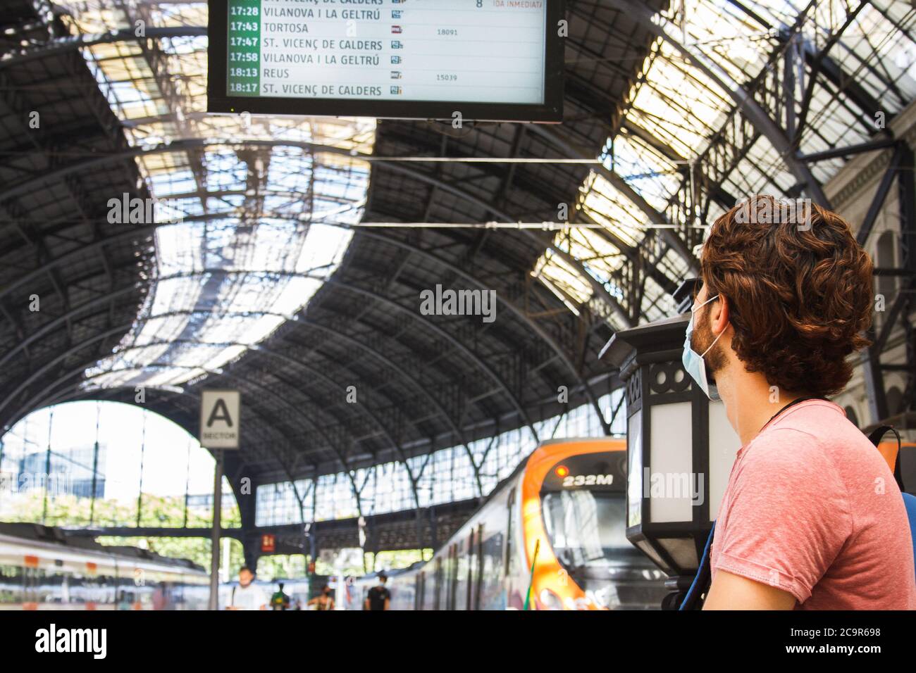 Young man checking train station timetables. Panoramic view. Travel safe covid times. Close view Stock Photo