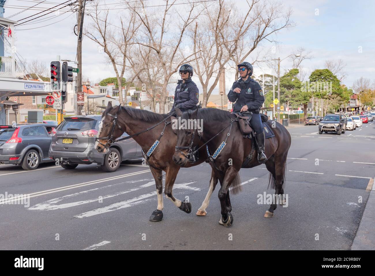 Mounted New South Wales Police women ride their horses along Crown Street in inner Sydney's Surry Hills, Australia Stock Photo