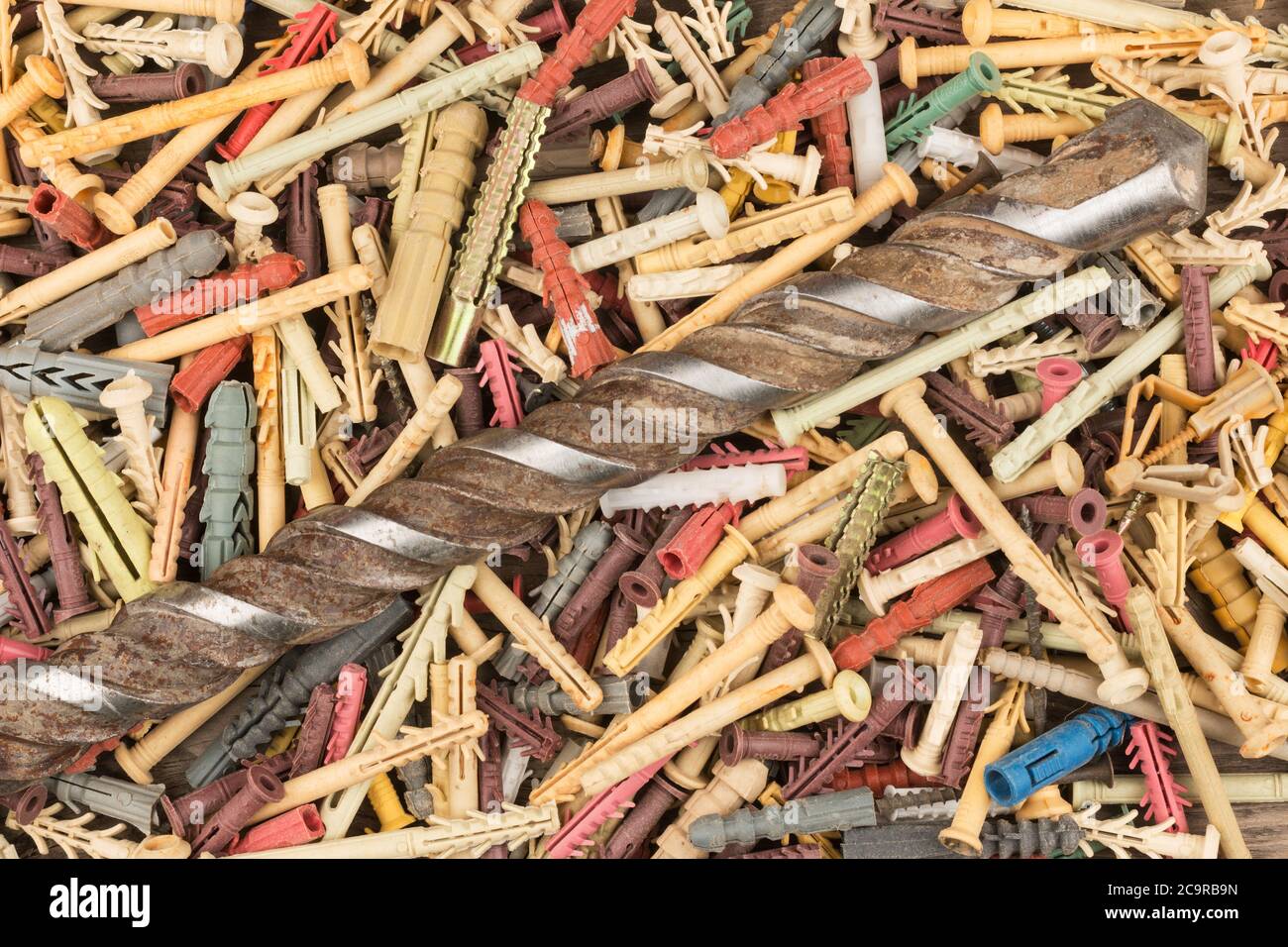 Old drill for drilling concrete lies on a pile of dowels. Closeup. Top