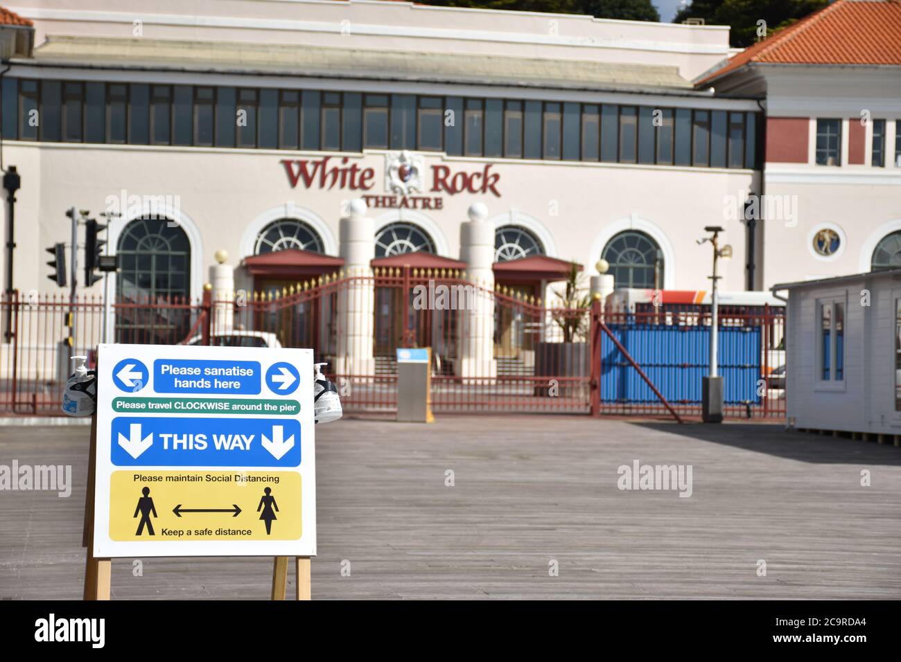 A social distancing sign in front of the White Rock Theatre viewed from Hastings pier during the 2020 Covid 19 crisis. Hastings, Sussex, England, UK. Stock Photo