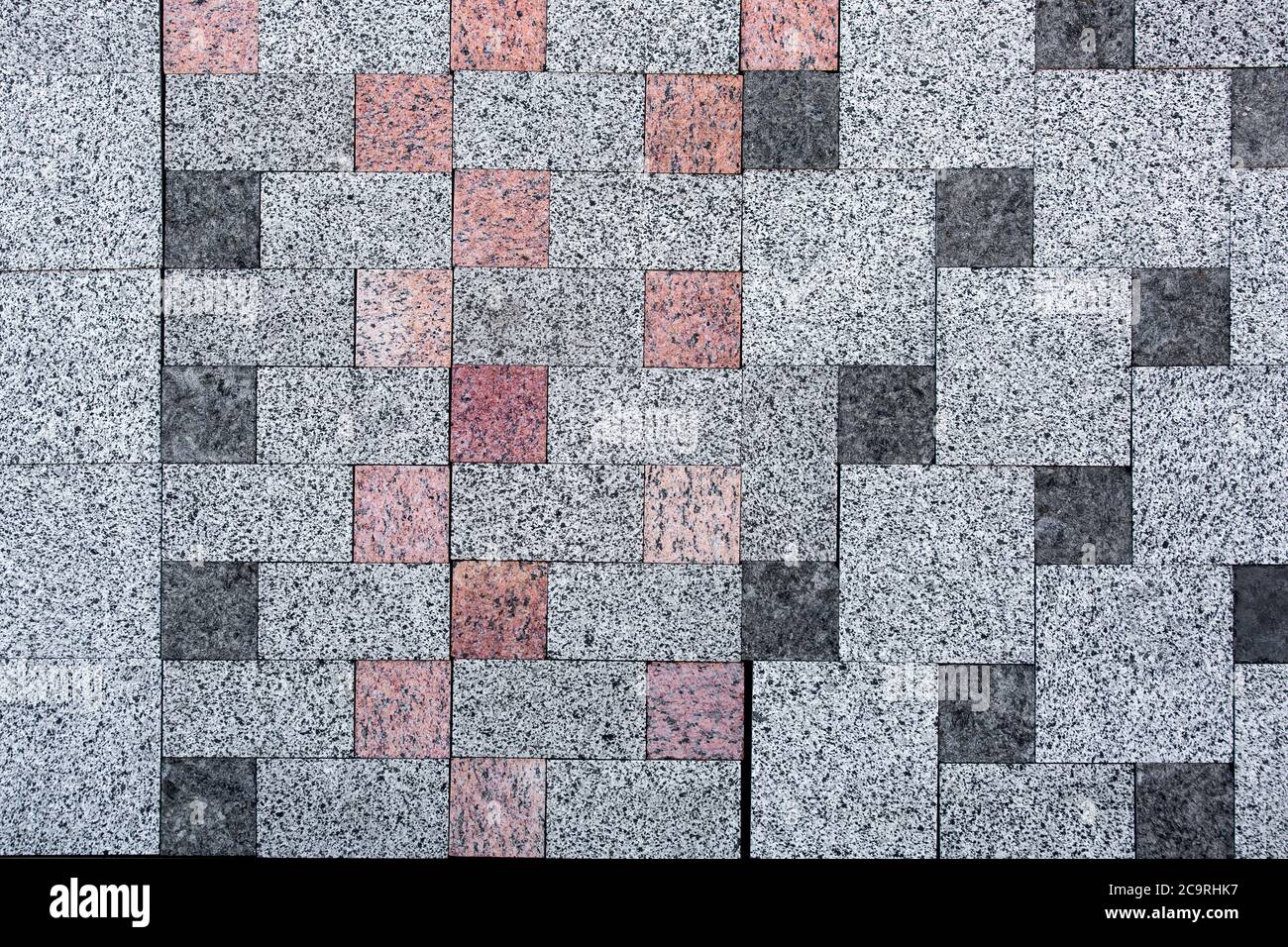 sidewalk stone, texture of a decorative stone for paving of sidewalks and roads.light gray with inserts dark gray and red. Stock Photo
