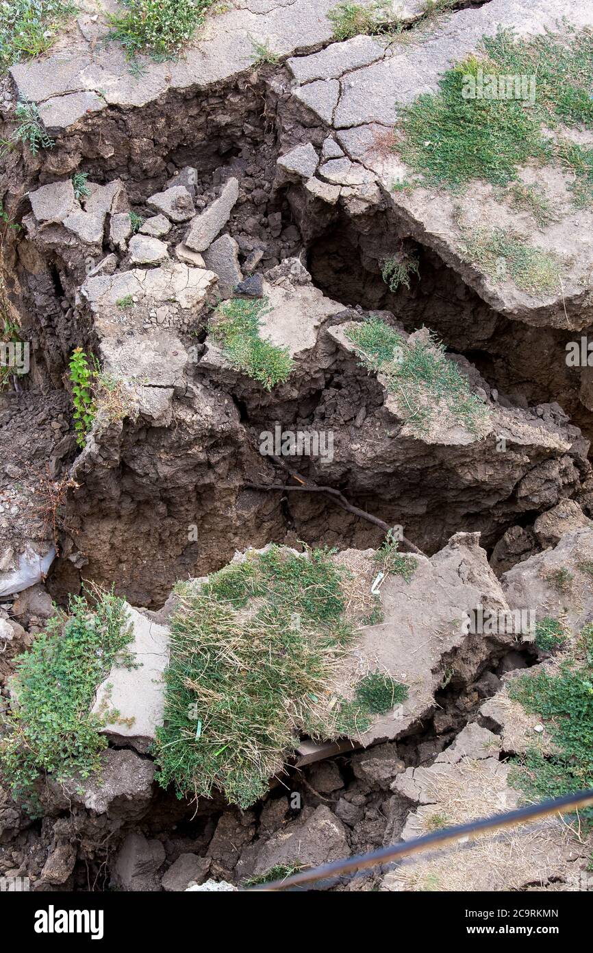 Consequences of a natural cataclysm of a landslide of soil, crack asphalt paving. Stock Photo