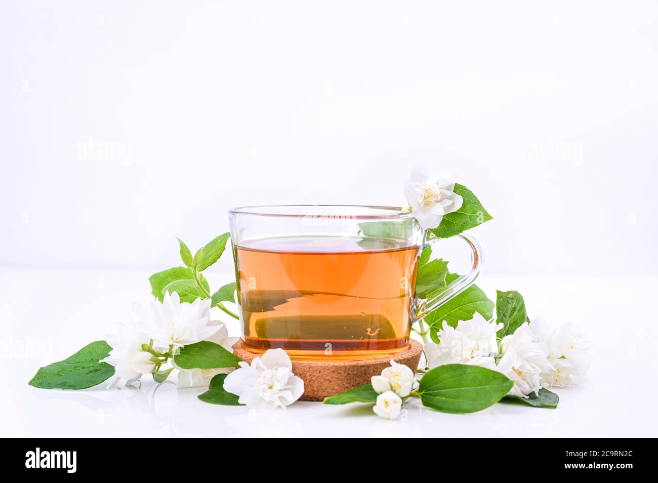 Jasmine tea. A traditional drink in China for health and vitality. Oriental medicine. Fresh jasmine flowers on white background and a cup of tea. Free space for text. Photos of light colors Stock Photo