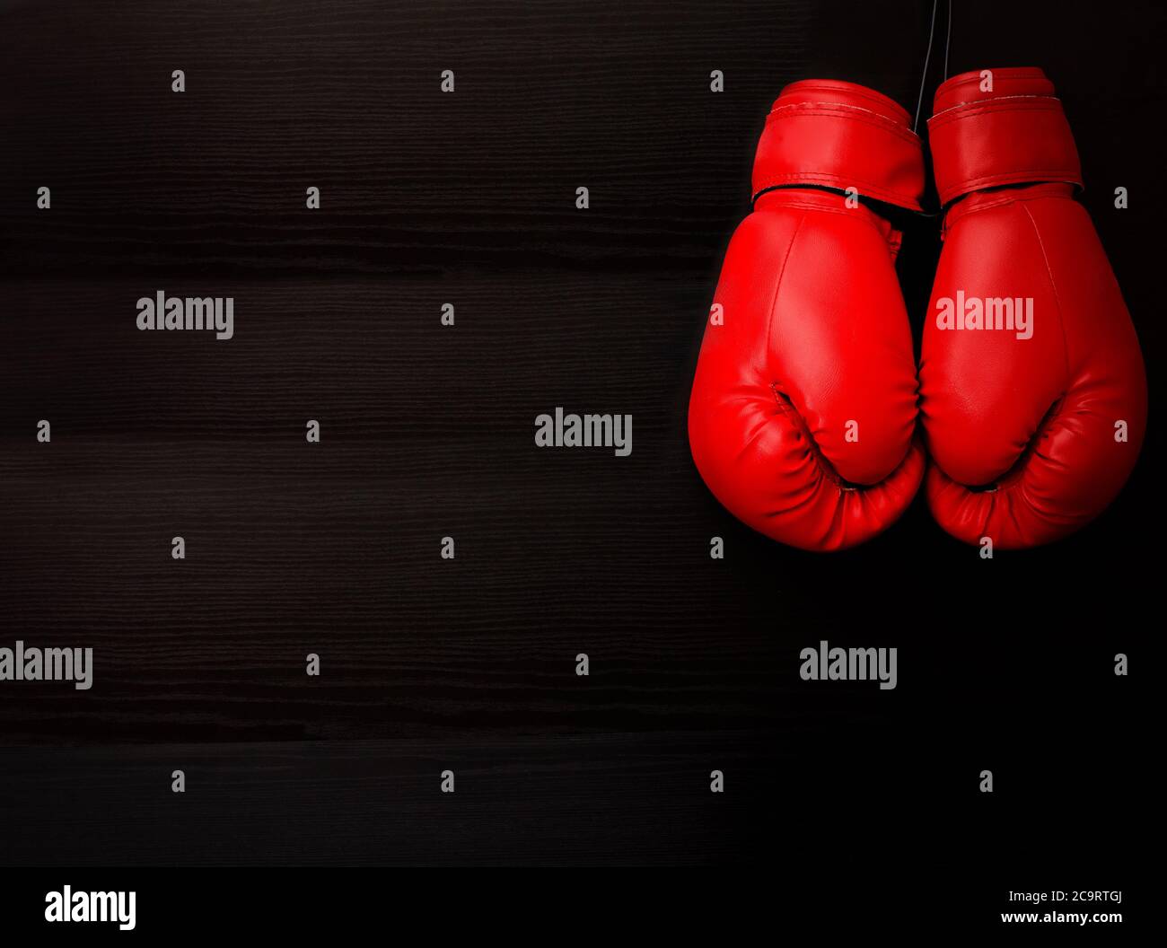 Two red boxing gloves in the upper corner of the frame over a black  background, empty space Stock Photo - Alamy