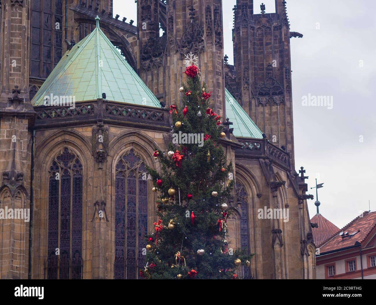 decorated christmas tree with red balls and ribbon in front of prague saint vitus gothic cathedral Stock Photo