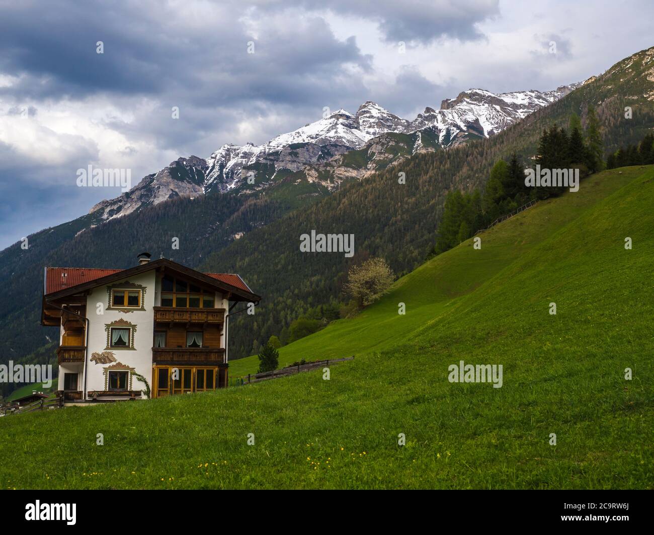 Lush green meadow,Idyllic spring mountain rural landscape. View over Stubaital or Stubai Valley near Innsbruck, Austria with rustic wooden cottage in Stock Photo