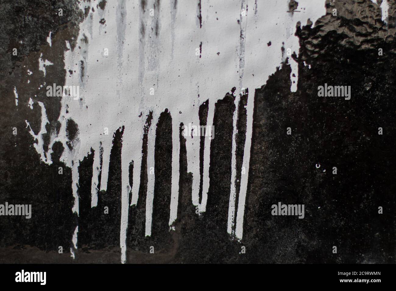 White paint dripping down on a dirty structured glass texture for background Stock Photo