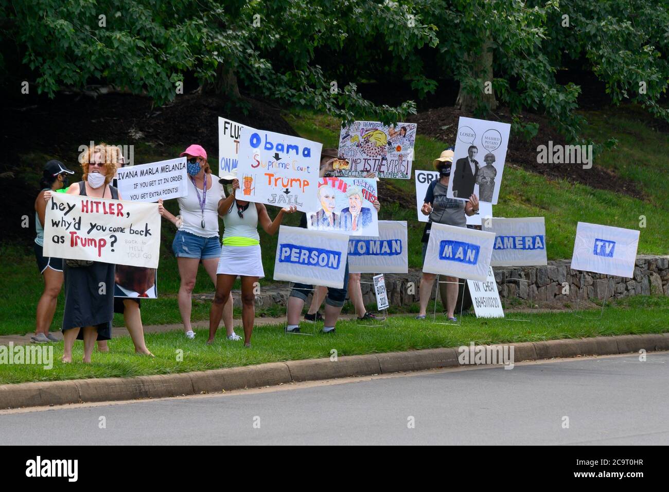 Protesters hold signs outside the Trump National Golf Club in Sterling, Virginia U.S., on Saturday, August 1, 2020. Credit: Erin Scott/Pool via CNP /MediaPunch Stock Photo