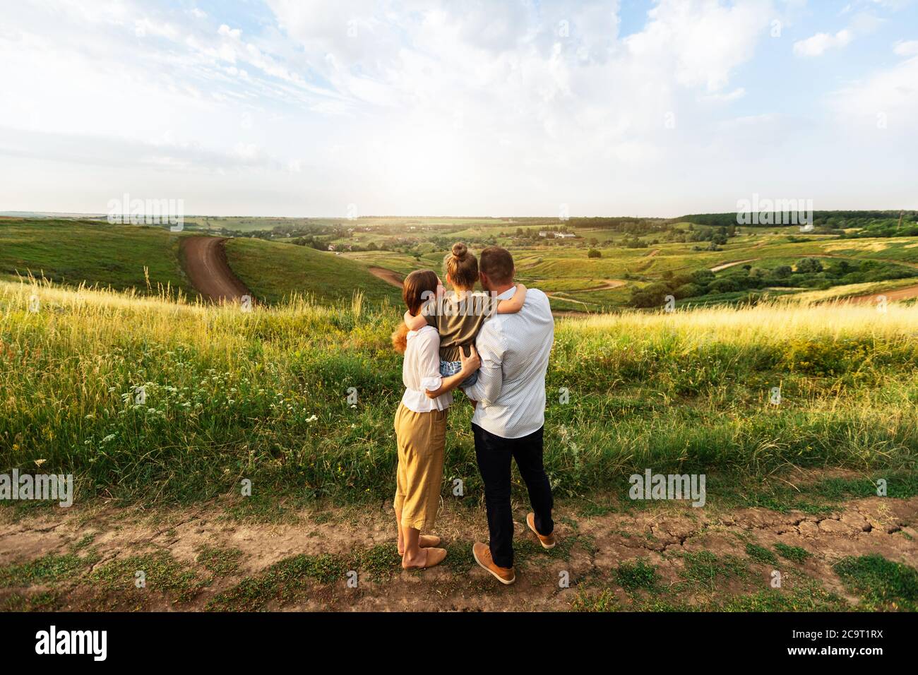 Happy family enjoying beautiful landscape outdoors in the field Stock Photo