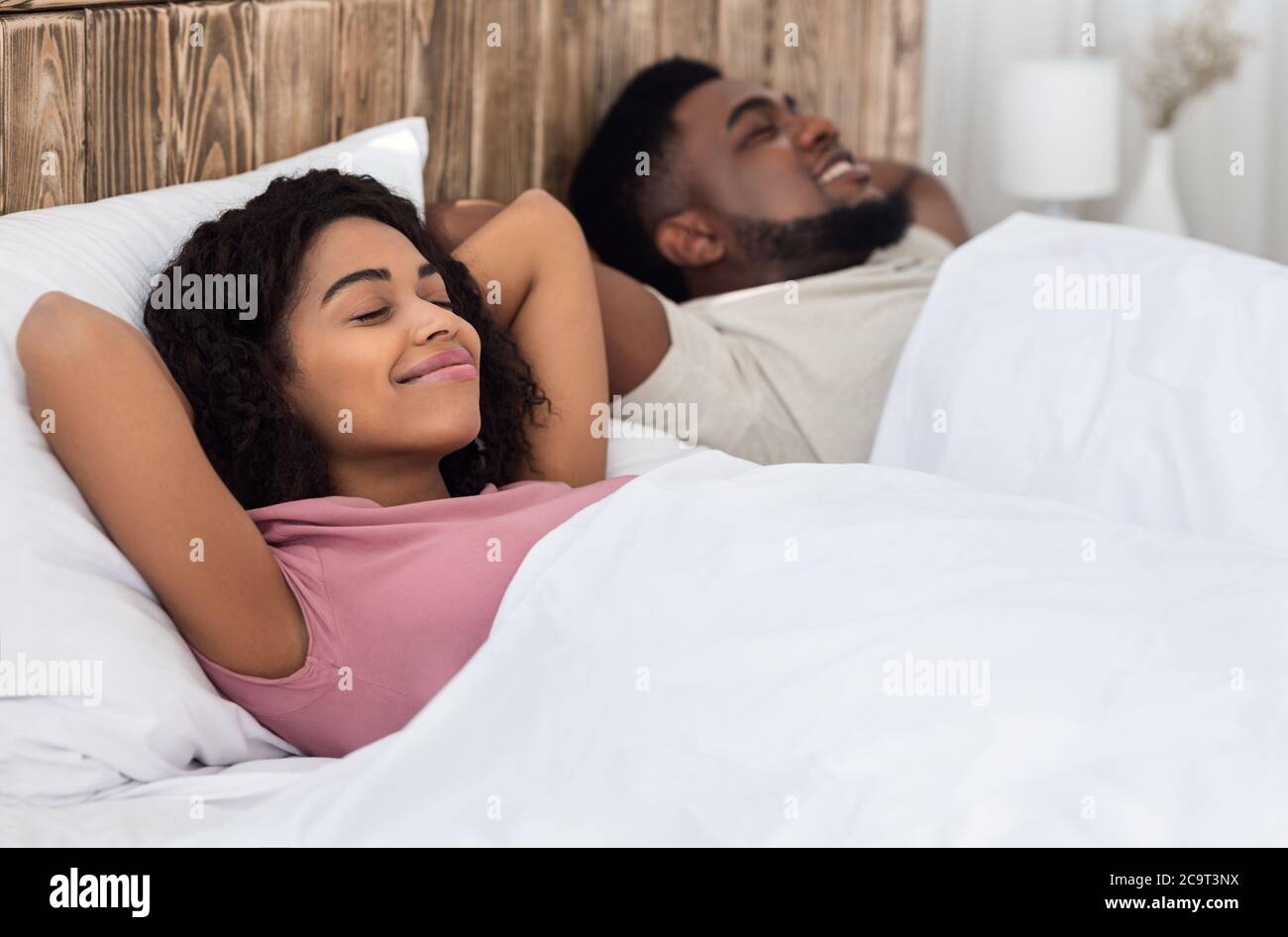 Relaxed african couple enjoying their new bed Stock Photo - Alamy