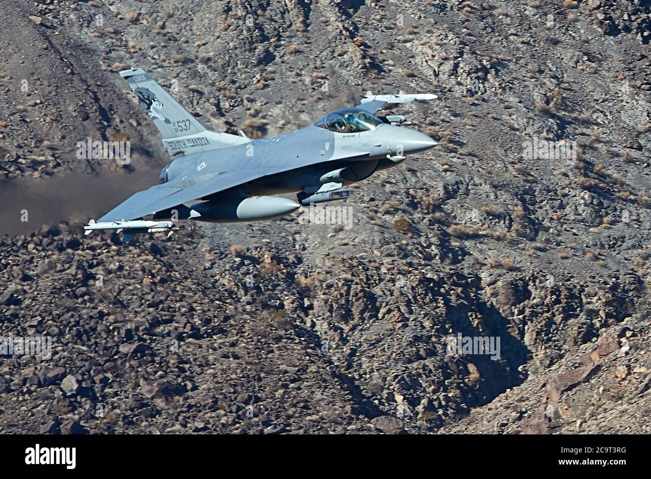 South Dakota Air National Guard F-16C, Flying At High Speed And Low Altitude Through Rainbow Canyon, California, USA. Stock Photo