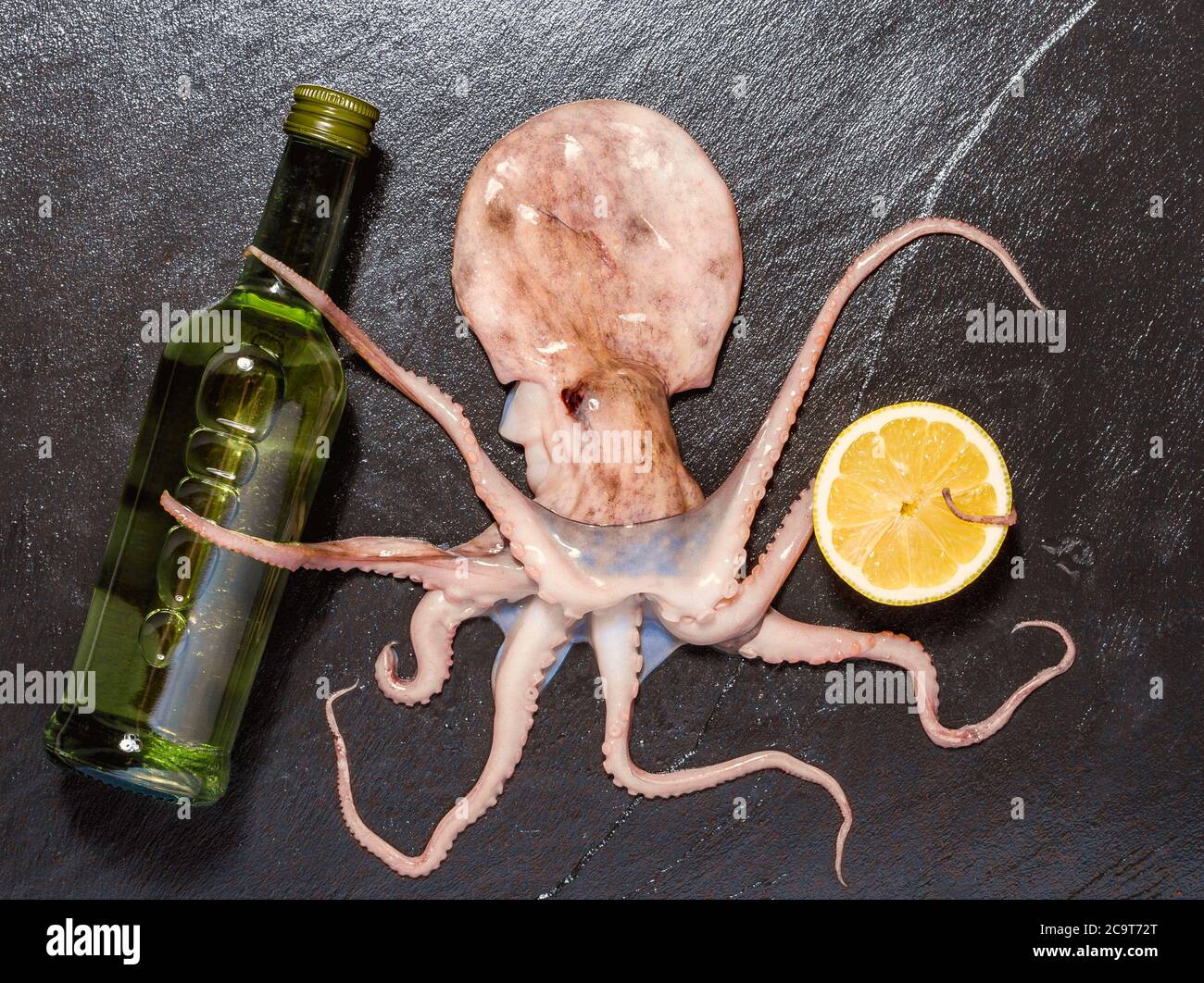 Octopus hold wine, on black slate, top view Stock Photo
