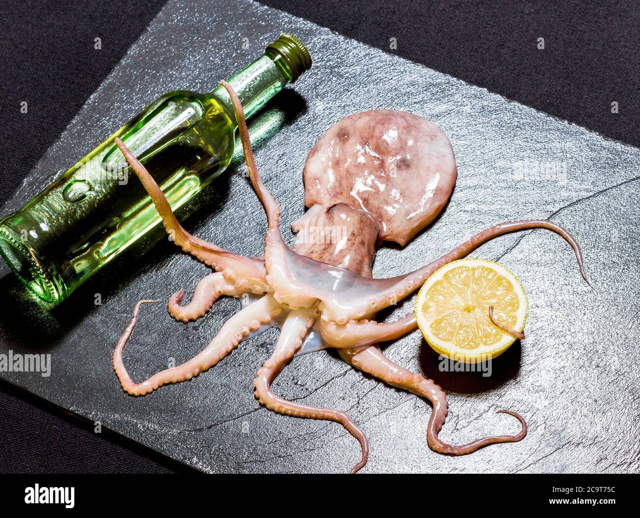 Octopus hold wine, on black slate, top view Stock Photo