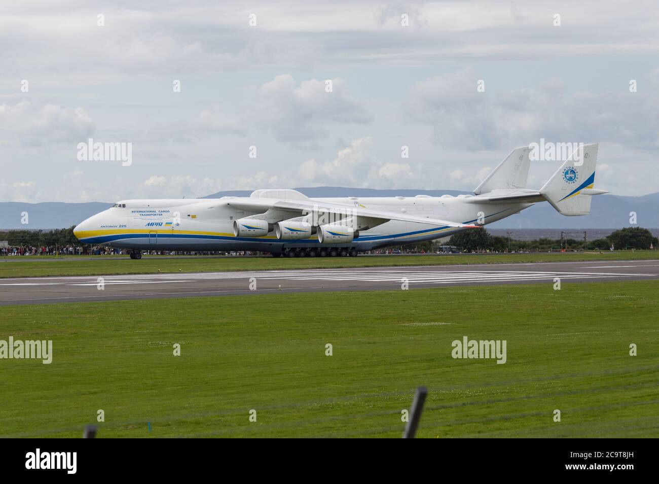 Prestwick, Scotland, UK. 2 August 2020 Pictured: Crowds of aviation enthusiasts and plane spotters turned out to see the Antonov An-225 Mryia (Reg UR-82060) make a scheduled arrival for a refeulling stop at Glasgow Prestwick Airport from Bangor, USA before departing at 4.30pm for Châteauroux-Centre Airport in France. The giant strategic airlift cargo plane behemoth is powered by six massive Six Ivchenko Progress Lotarev D-18T three shaft turbofan engines, has a maximum takeoff weight of 640 tonnes. Credit: Colin Fisher/Alamy Live News Stock Photo
