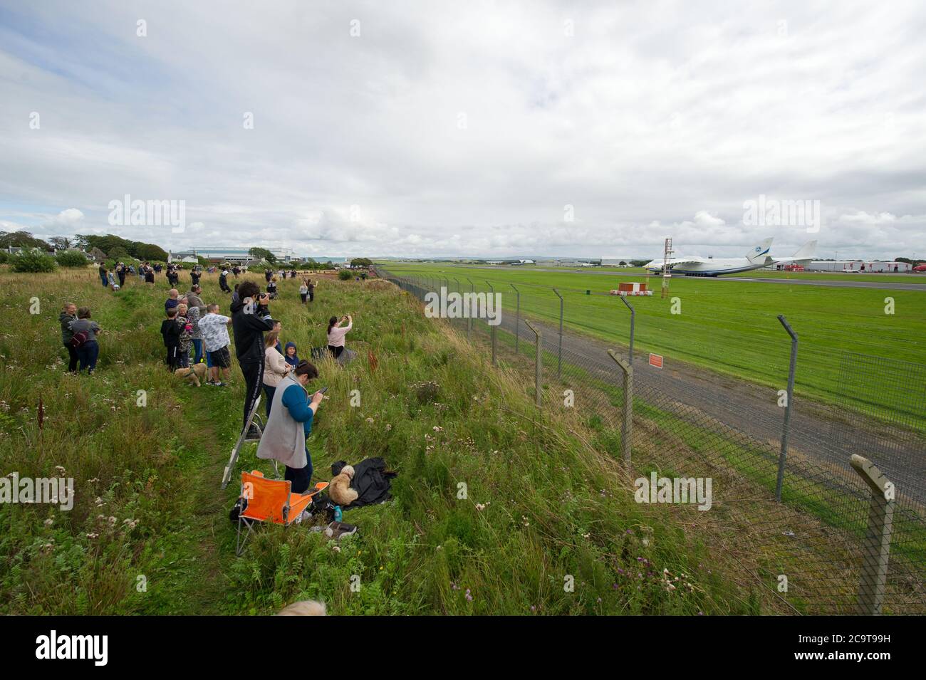Prestwick, Scotland, UK. 2 August 2020 Pictured: Crowds of aviation enthusiasts and plane spotters turned out to see the Antonov An-225 Mryia (Reg UR-82060) make a scheduled arrival for a refeulling stop at Glasgow Prestwick Airport from Bangor, USA before departing at 4.30pm for Châteauroux-Centre Airport in France. The giant strategic airlift cargo plane behemoth is powered by six massive Six Ivchenko Progress Lotarev D-18T three shaft turbofan engines, has a maximum takeoff weight of 640 tonnes. Credit: Colin Fisher/Alamy Live News Stock Photo