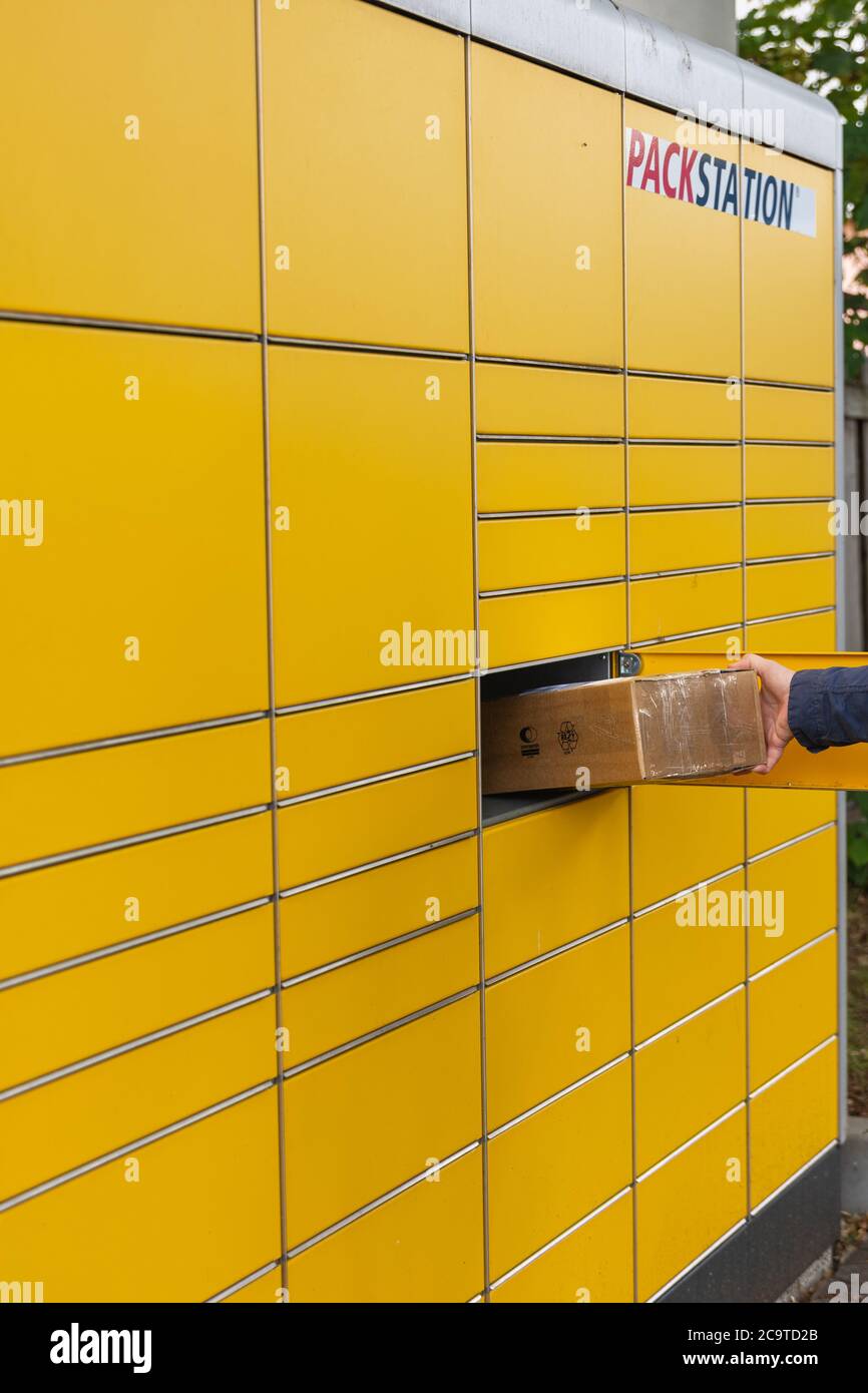 DHL Packstation, where customers can pick up their order themselves and  also send packages. See here how a customer inserts his parcel for  transportat Stock Photo - Alamy