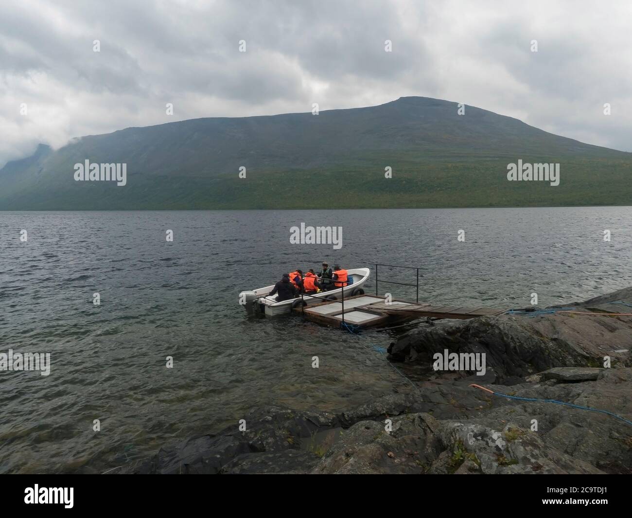 group of tourist hikers on motor boat at pier prepar to crossing Teusajaure lake at Kungsleden hiking trail. Lapland mountains nature landscape in sum Stock Photo