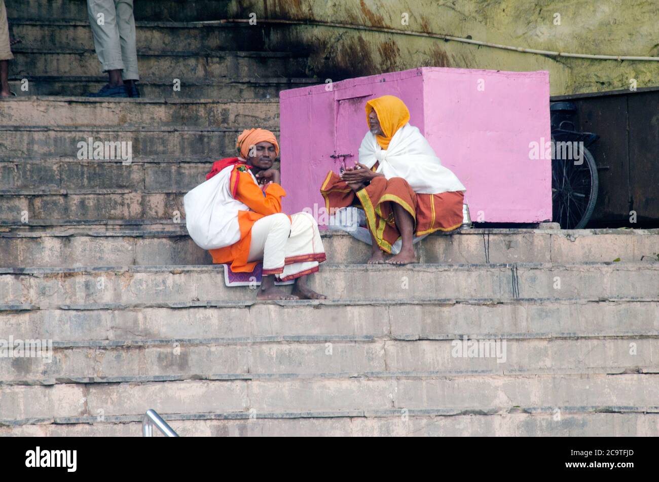 two sadhus sitting on stairs at varanasi ganga ghat Stock Photo