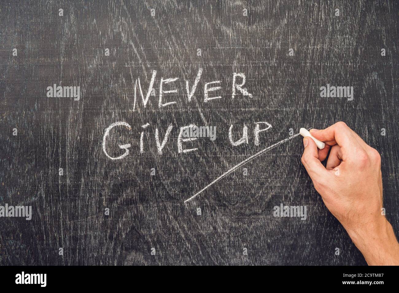 Never give up words written on the chalkboard Stock Photo