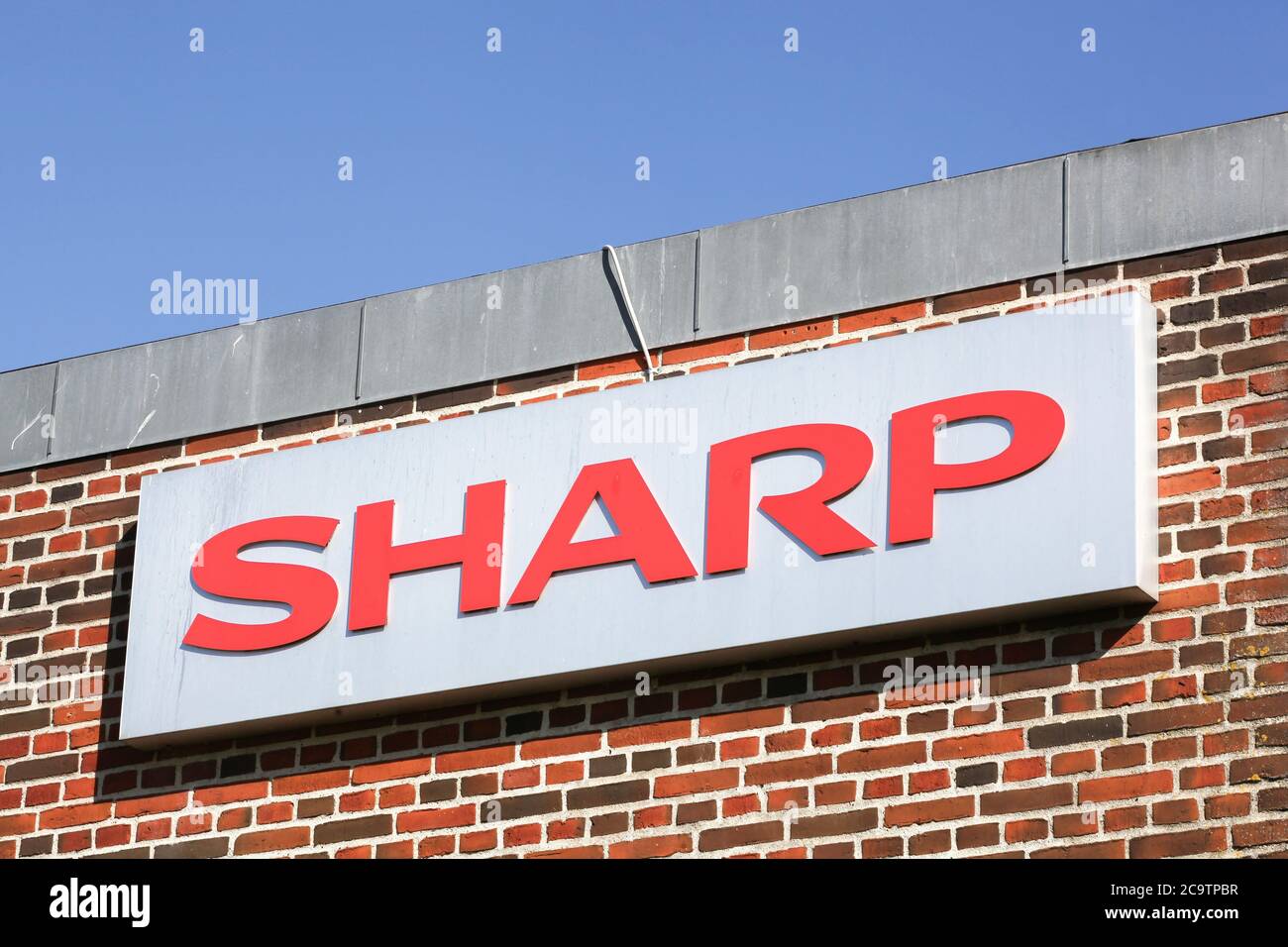 Ega, Denmark - May 11, 2019: Sharp logo on a facade. Sharp is a Japanese multinational corporation that designs and manufactures electronic products Stock Photo