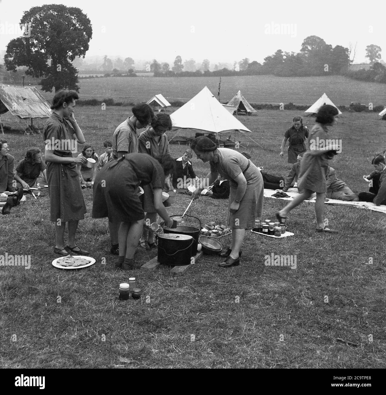 1950s, historical, girl guides and visitors at camp, outside serving