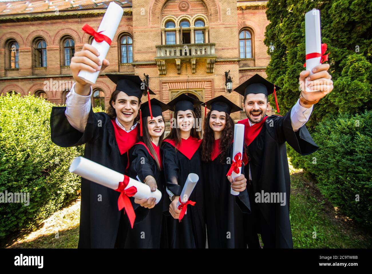 Happy graduation day. 5 graduates hold his graduate diplomas in their ...