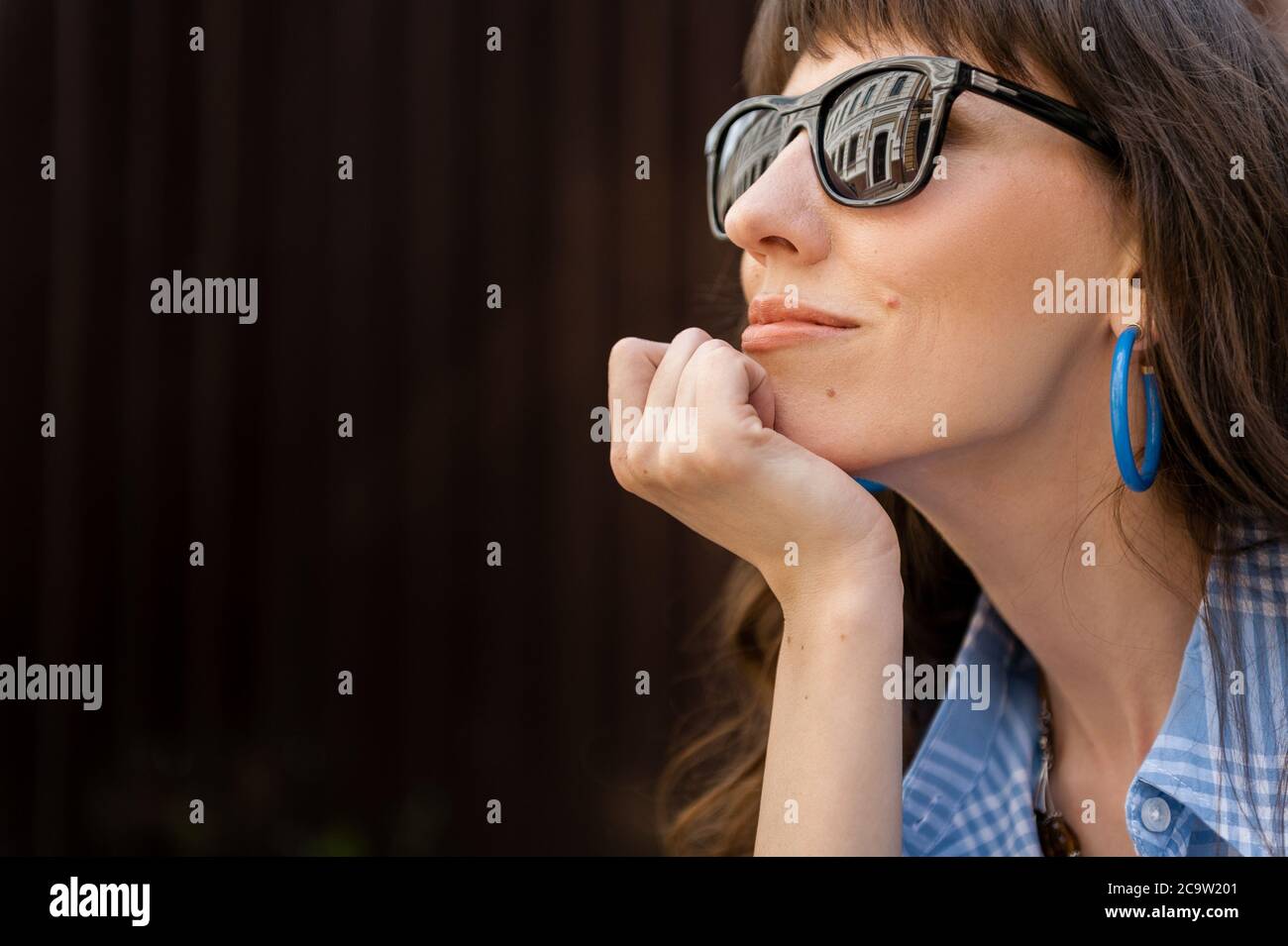 A large portrait of a girl in the city. Beautiful girl with glasses Stock Photo