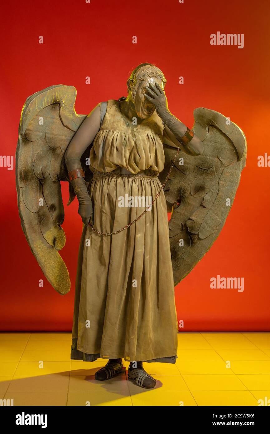 Actress woman in mask and costume of fictional fantasy character posing on red background Stock