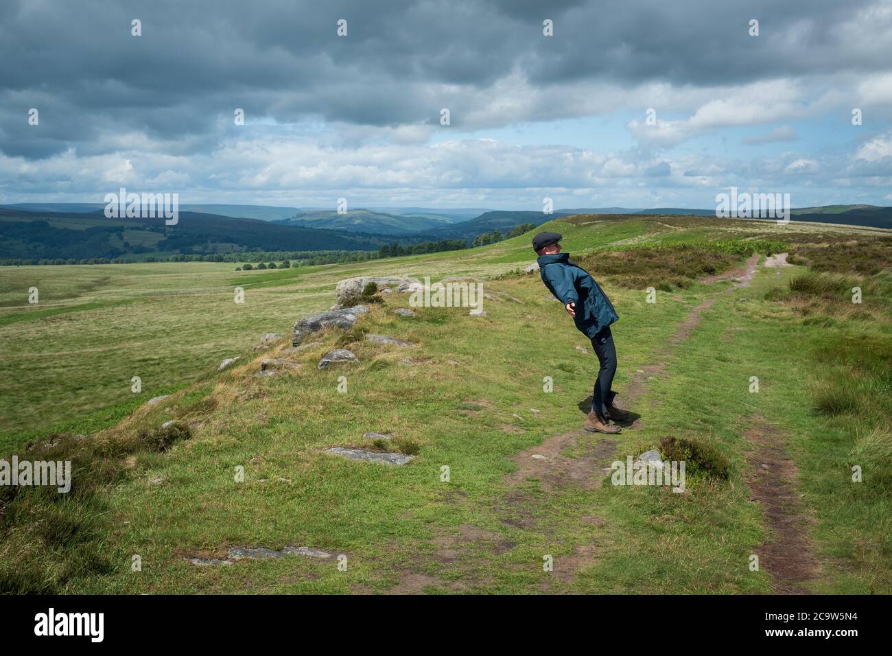 Man leaning against the wind, White Edge, Peak District, UK Stock Photo