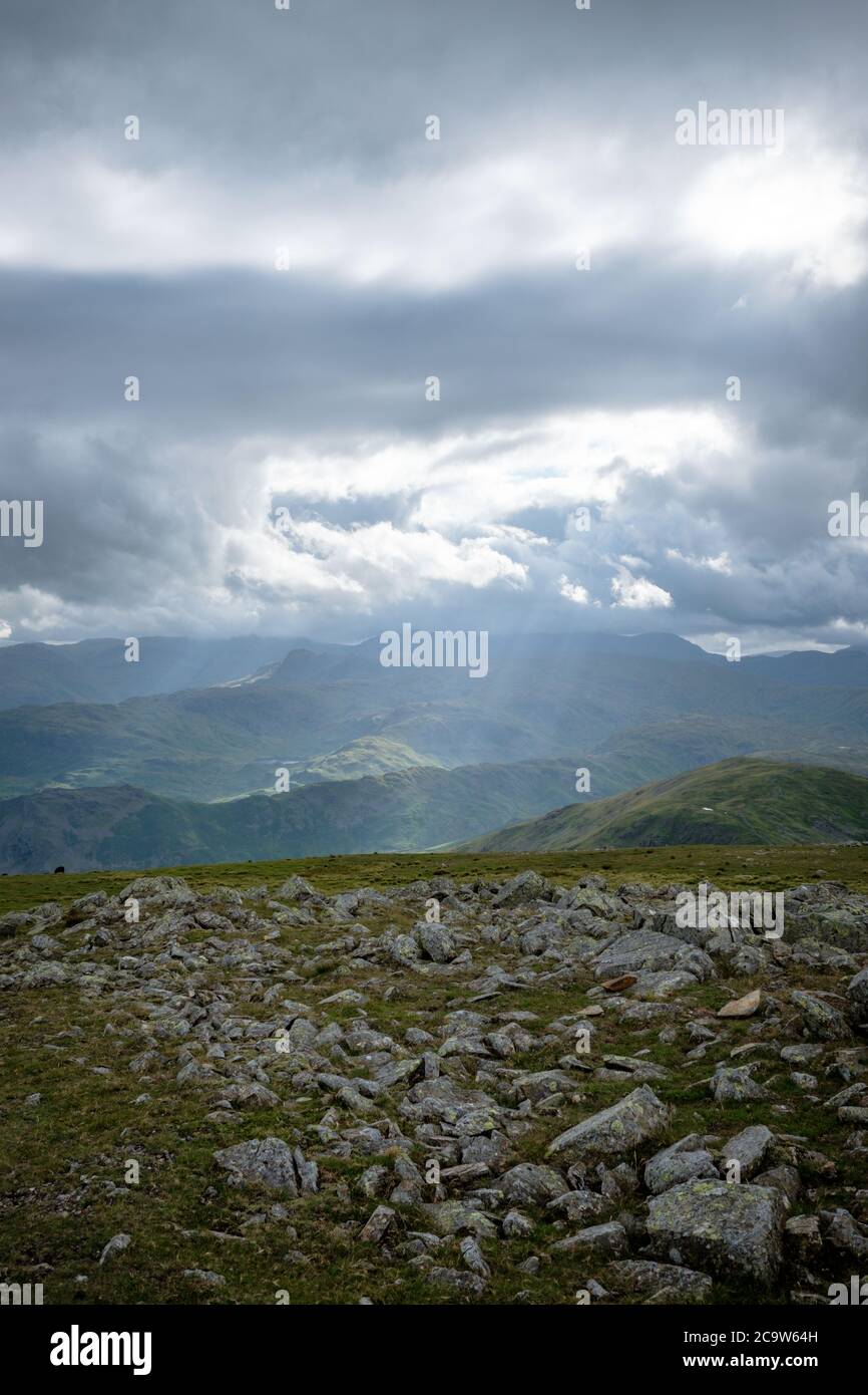 Shafts of sunlight on Easdale and Grasmere Common from the summit of Helvellyn, Lake District, UK Stock Photo