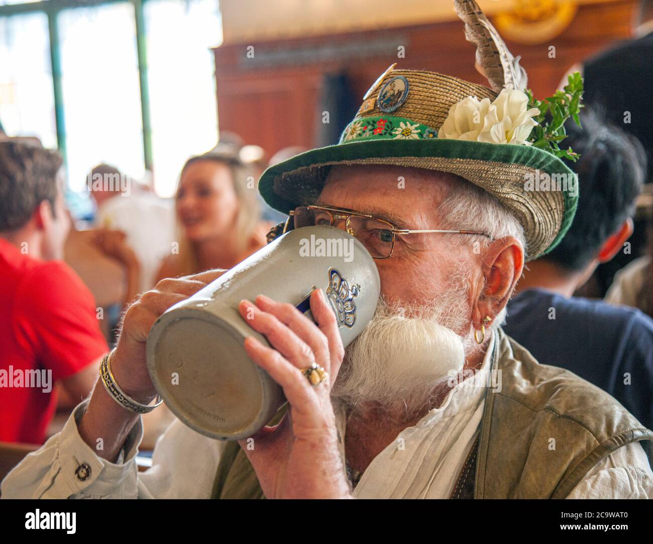 Man in Bavarian dress drinks his beer, Hofbrauhaus, Munich, Bavaria, Germany. Stock Photo