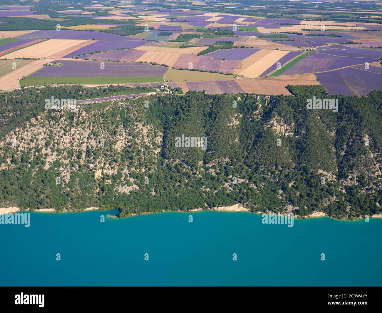 AERIAL VIEW. Lavender fields on the Valensole Plateau overlooking Lake Sainte-Croix. Moustiers-Sainte-Marie, Provence, France. Stock Photo