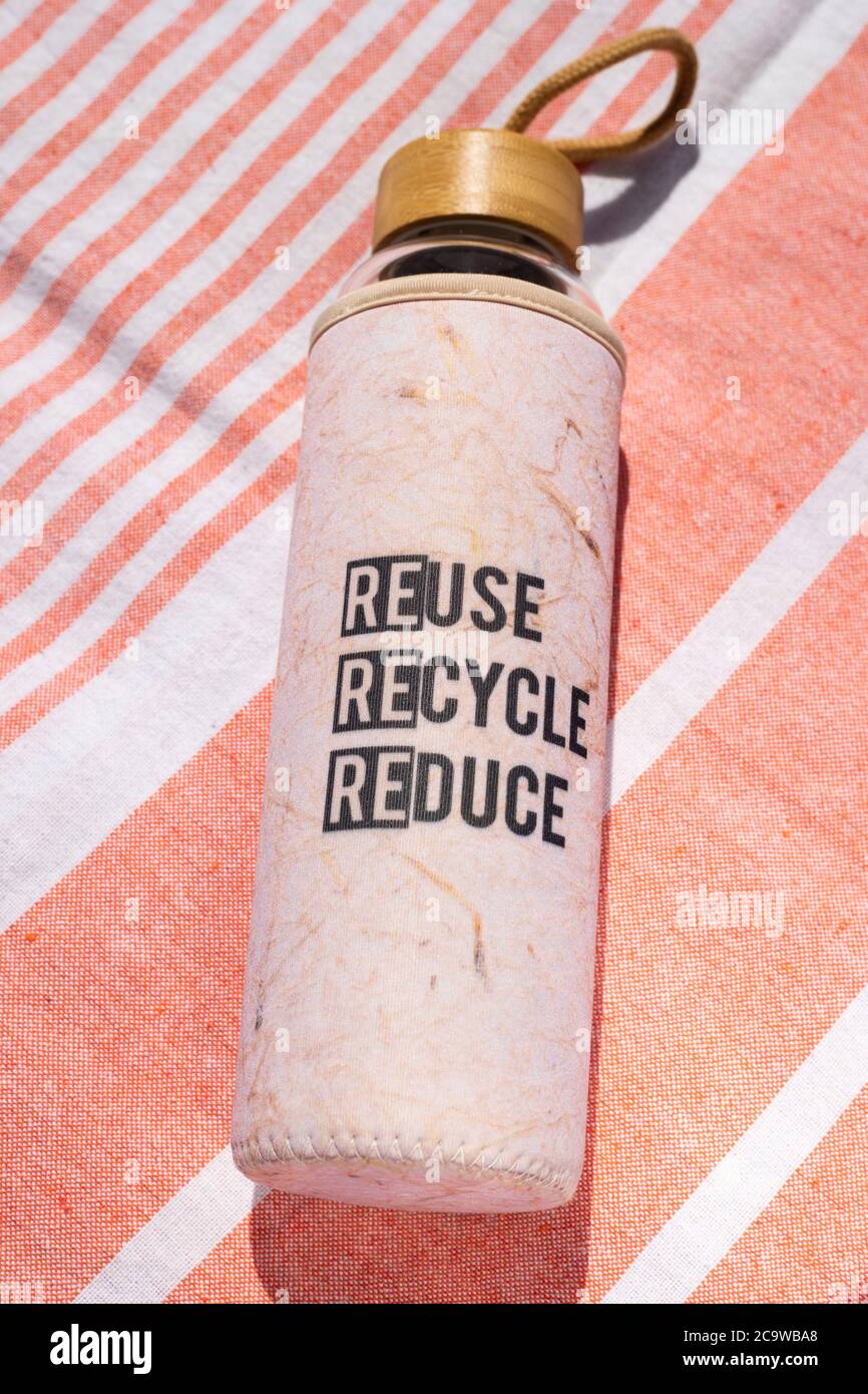 reuse recycle reduce patterned glass drink bottle with a bamboo lid Stock Photo