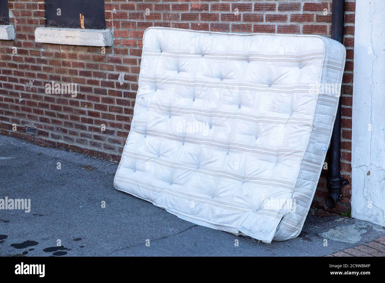 A mattress dumped or fly tipped in the street Stock Photo