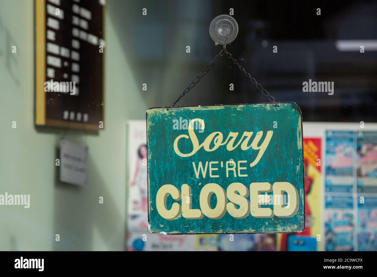 A sign hanging in a shop window saying sorry we are closed Stock Photo