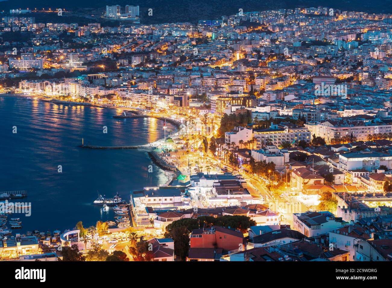 Kusadasi, Aydin Province, Turkey. Waterfront And Kusadasi Cityscape In Summer Evening. Night