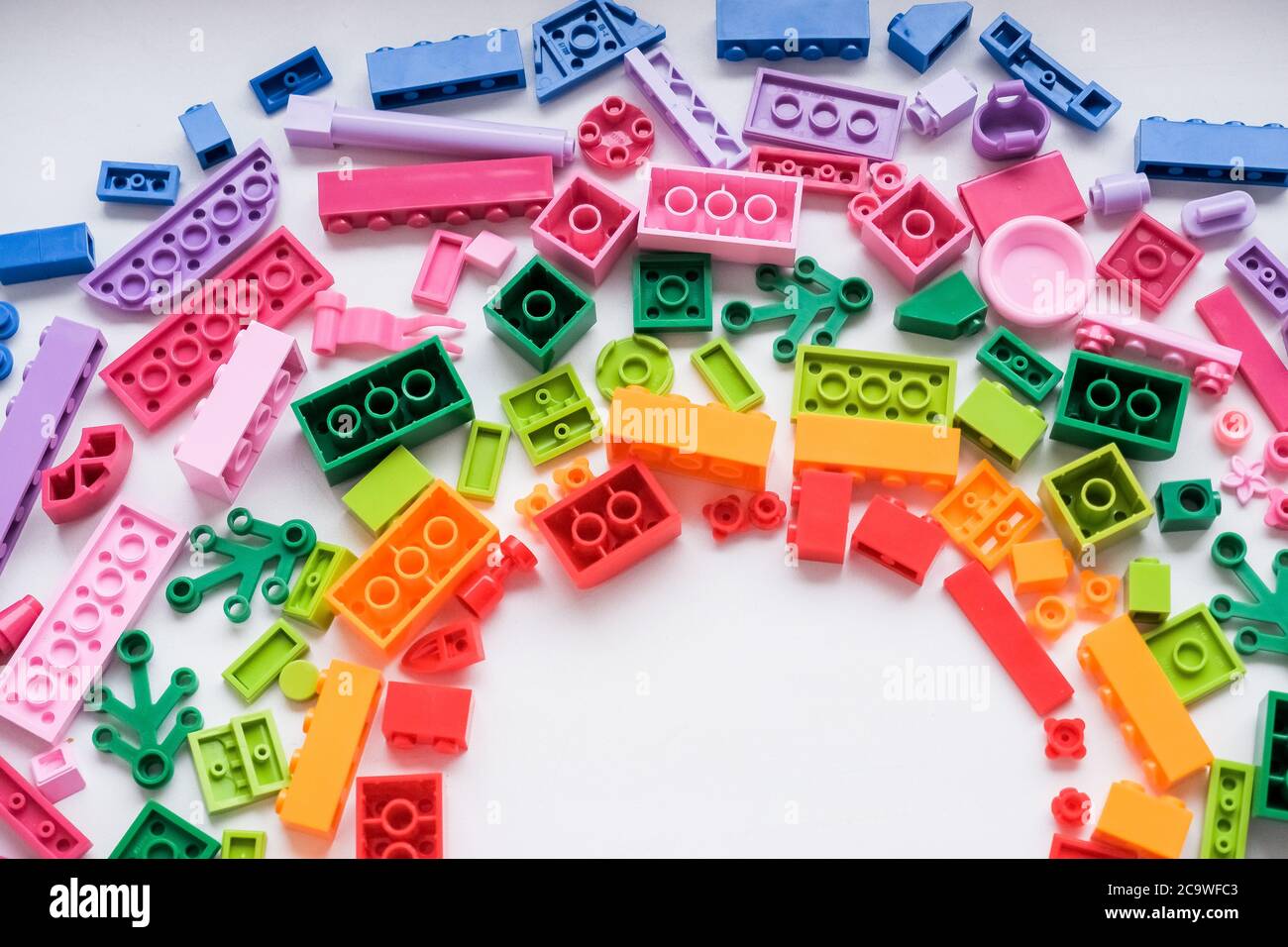 Toys background. Colorful cubes and plastic construction blocks frame on white background.Frame from different shapes plastic blocks.Creative, logical Stock Photo